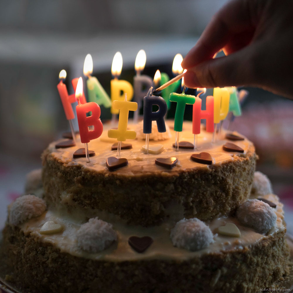 birthday cake with happy birthday candles lit
