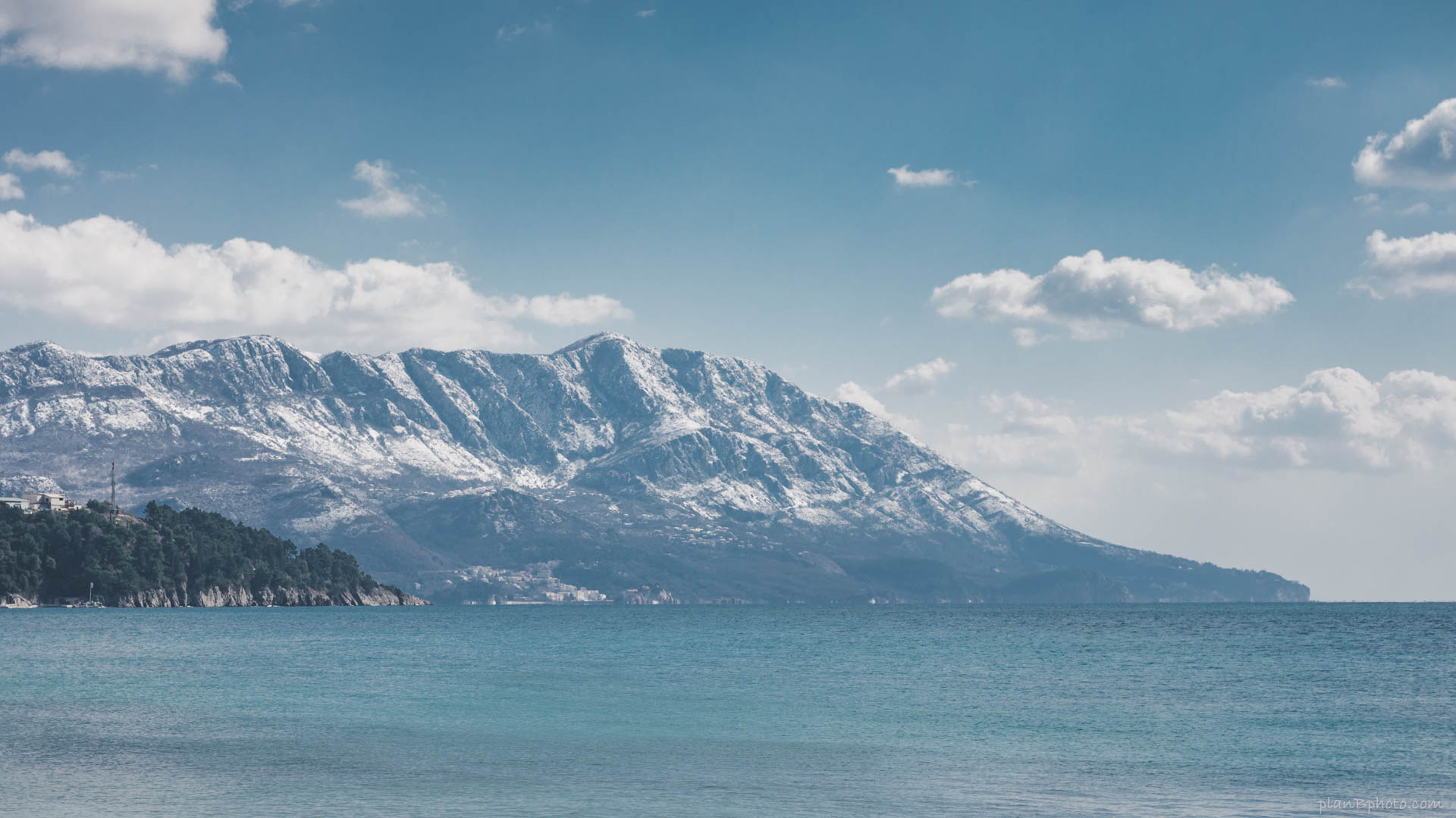 Mountain covered in snow by the blue sea