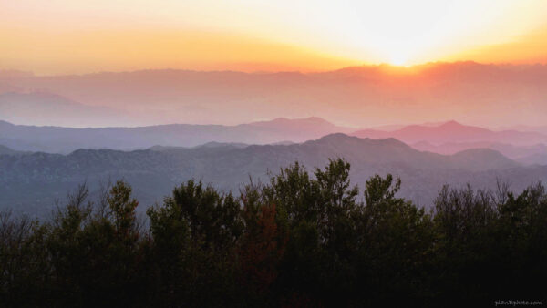 Colourful sunrise image with foggy mountains