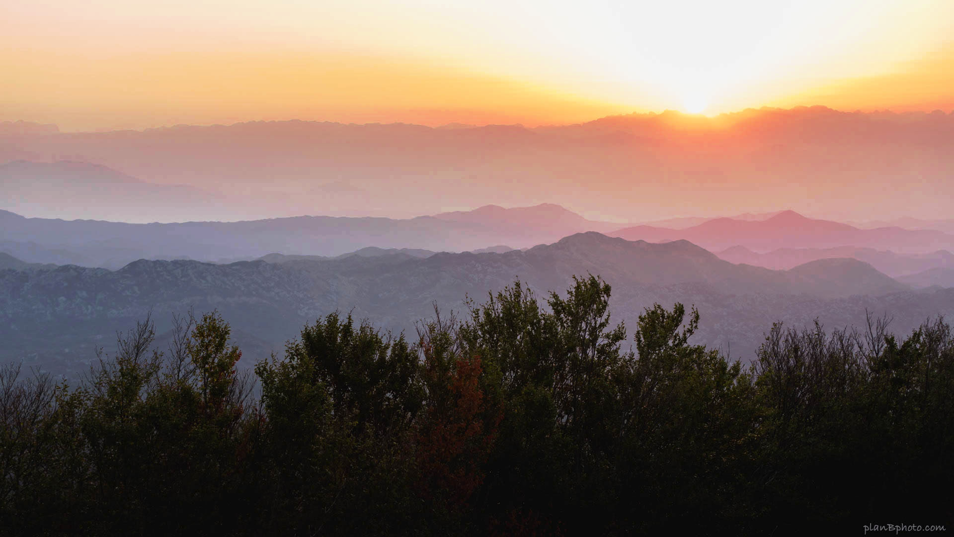 Colourful sunrise image with foggy mountains